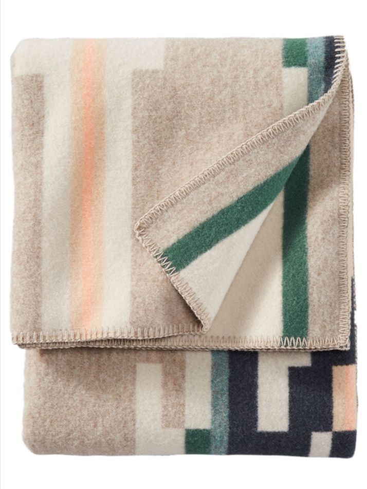 an image of a blanket with multi colored stripes on the top and bottom, folded in two