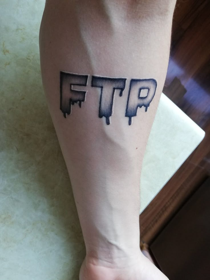 a person's foot with a tattoo on it that says ftp in black ink