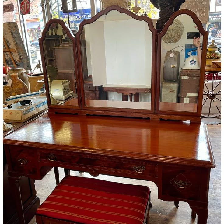 a wooden desk with a mirror and stool