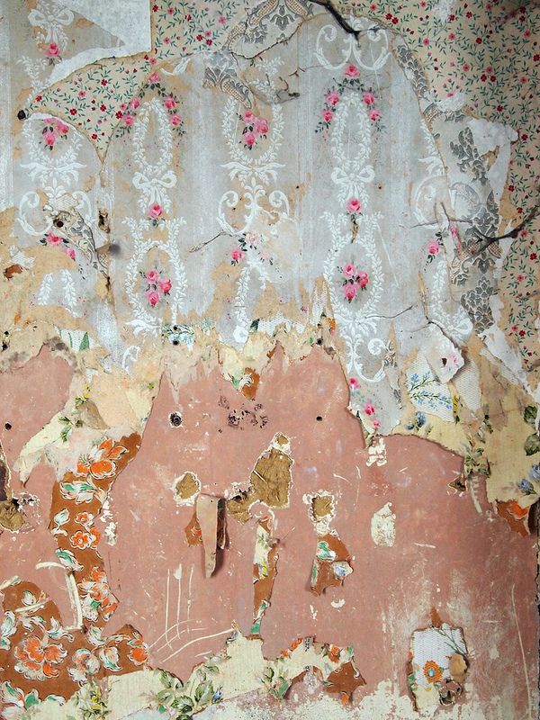 an old wall with peeling paint and floral designs on it's walls, including flowers