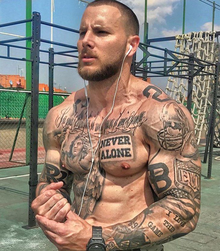 a man with tattoos on his chest wearing headphones