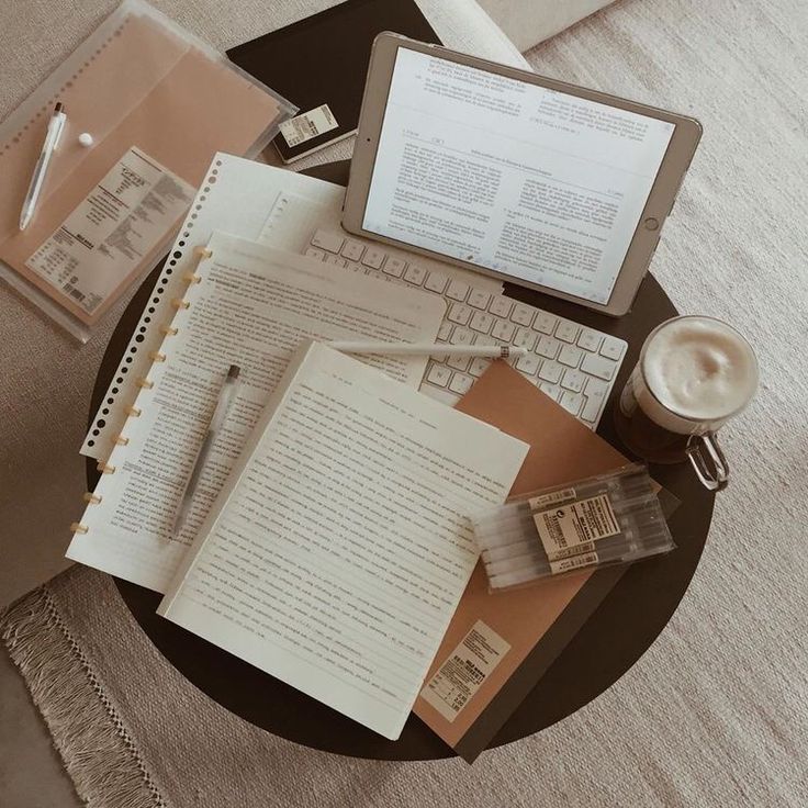 a table topped with an open book next to a laptop computer