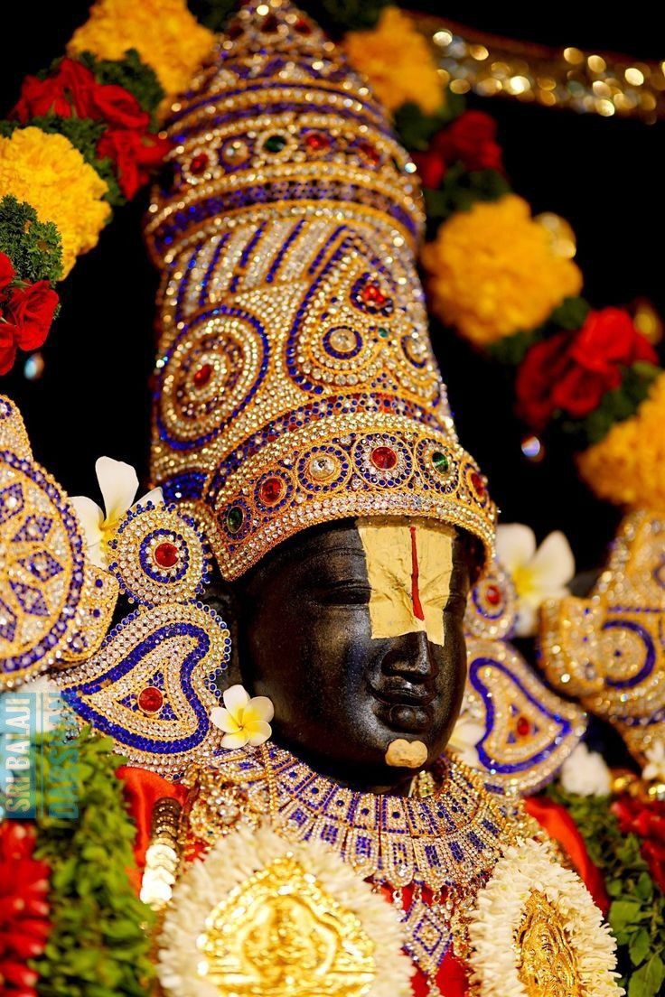 an elaborately decorated statue in front of flowers and garlands on display at a festival