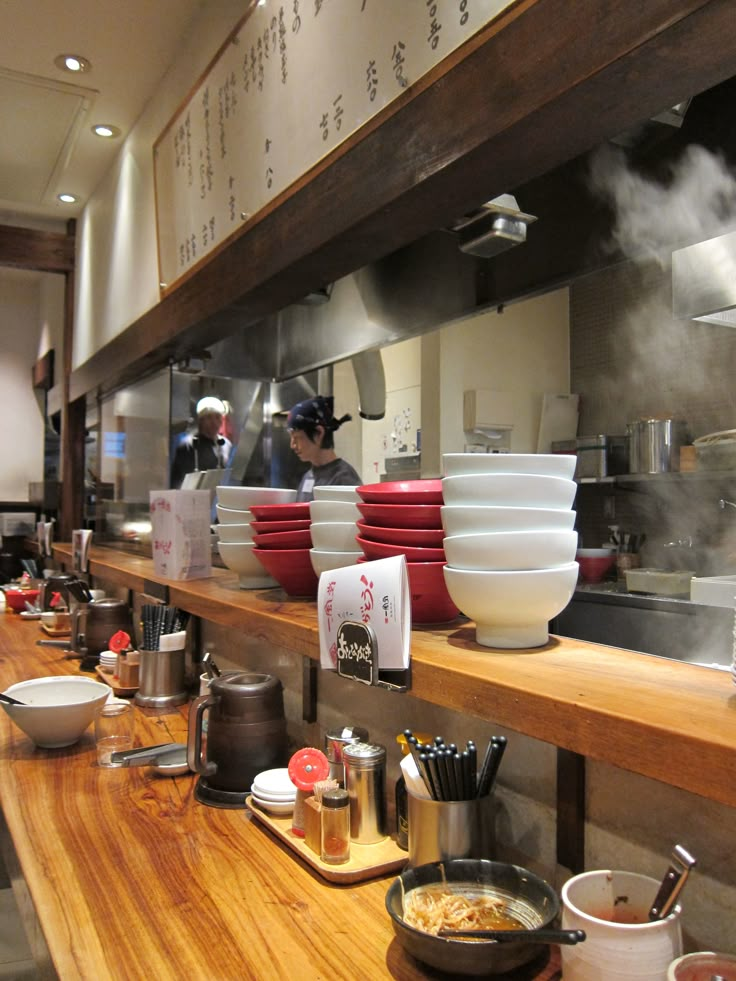 a chef preparing food in a kitchen with lots of bowls and pans on the counter