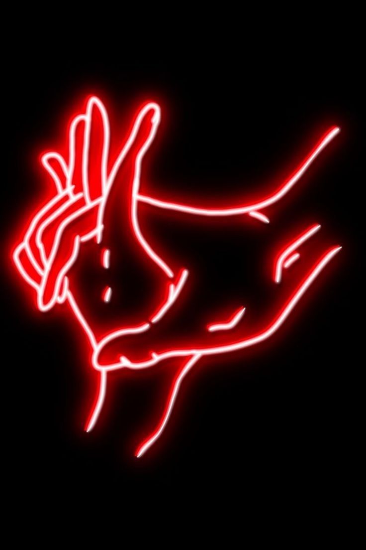 a red neon sign that is on the side of a black wall with a hand holding something in it