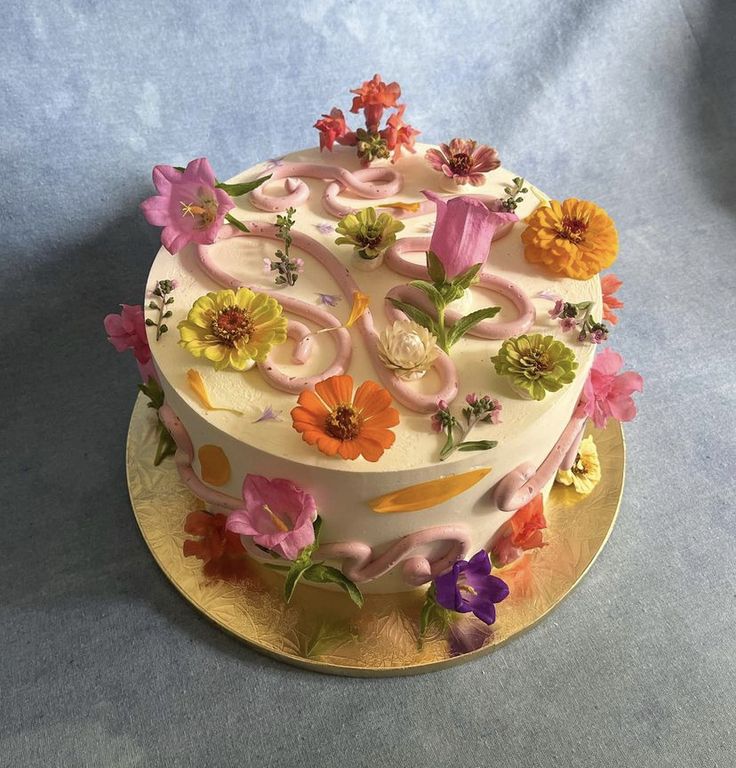 a cake decorated with flowers on a gold plate