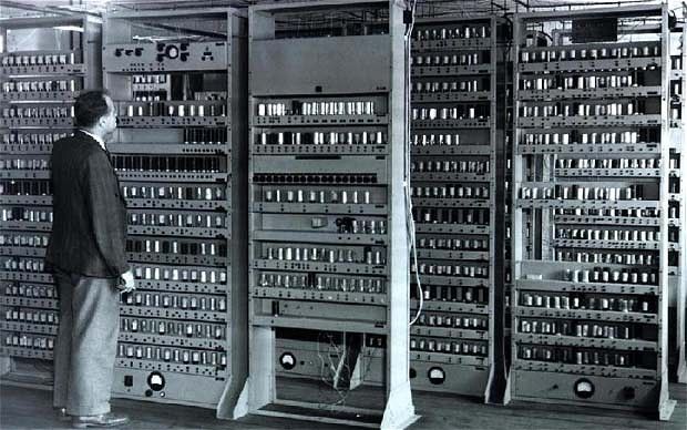 a man standing in front of a bunch of computer equipment