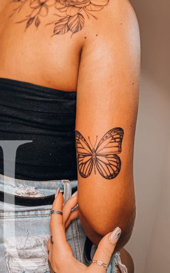 a woman with a butterfly tattoo on her arm