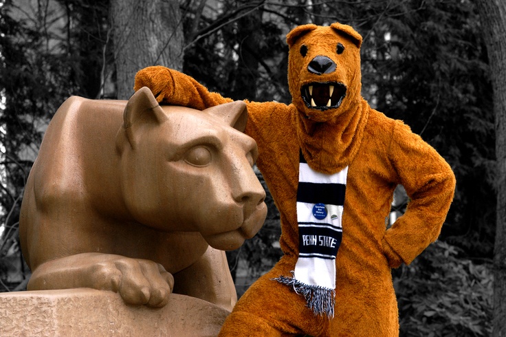 a person in a bear costume standing next to a statue