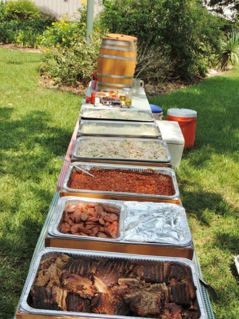 several trays of food are lined up on the grass