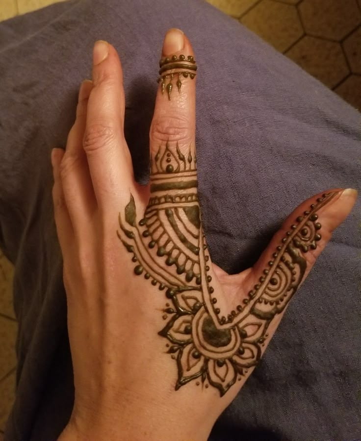 a woman's hand with henna tattoos on it