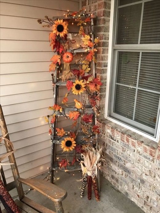 an old ladder is decorated with sunflowers and fall leaves