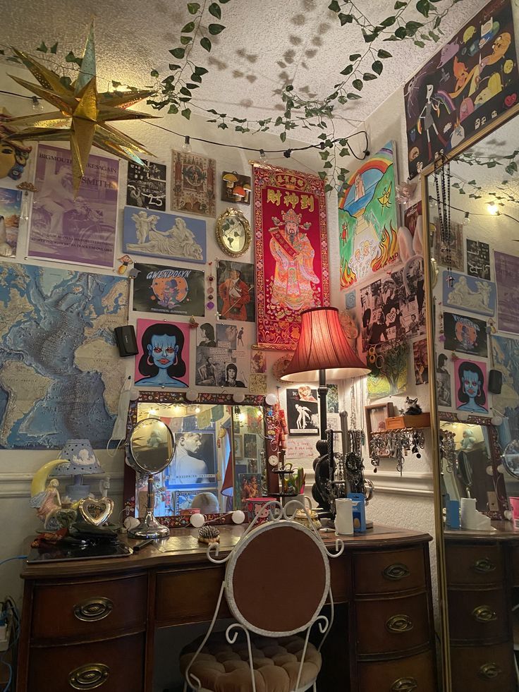 a room filled with lots of posters on the wall next to a dresser and lamp