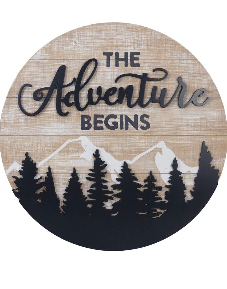 the adventure begins sign with trees and mountains painted on it's wood board, which reads