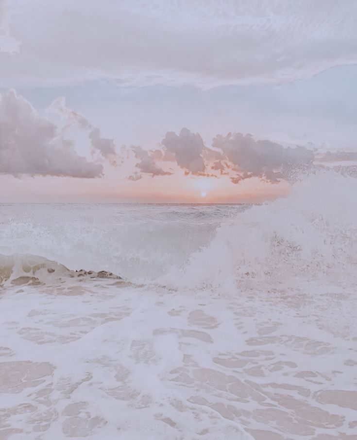 a person riding a surfboard on top of a wave in the ocean at sunset