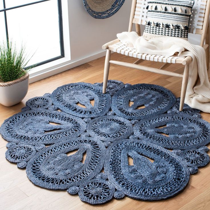 a blue rug is on the floor in front of a chair and potted plant