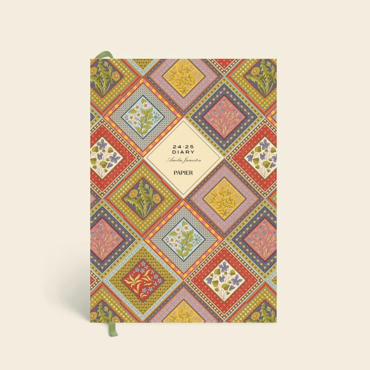 the front cover of a notebook with colorful squares and flowers on it's side