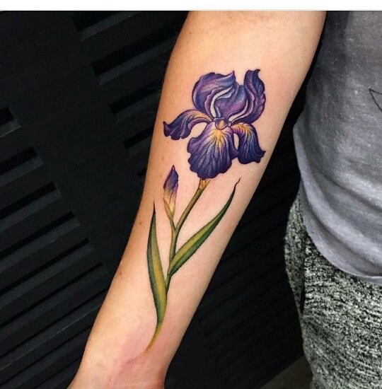 a woman's arm with a purple flower tattoo on it