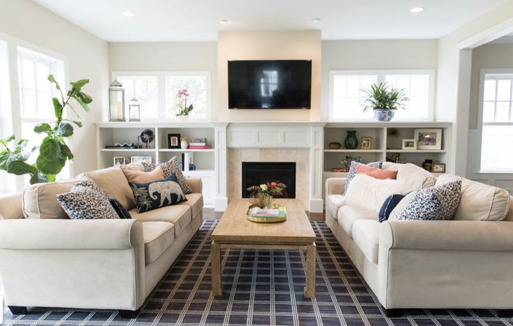 a living room filled with furniture and a flat screen tv mounted on the wall above a fireplace