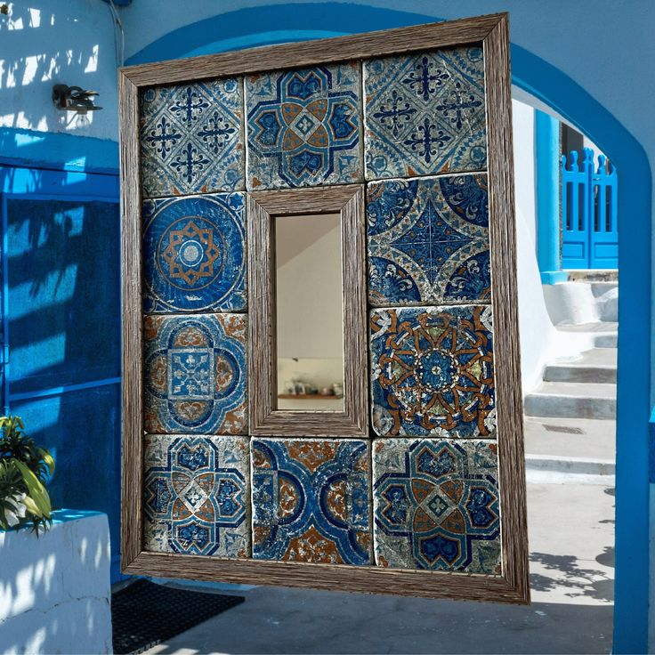 a blue and white building with a mirror on the wall next to it's doorway