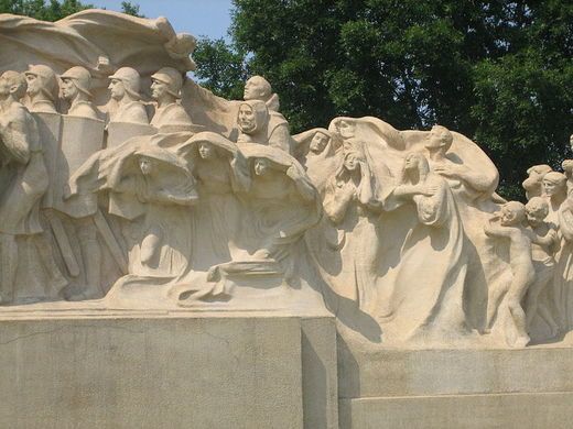 a group of statues with trees in the background