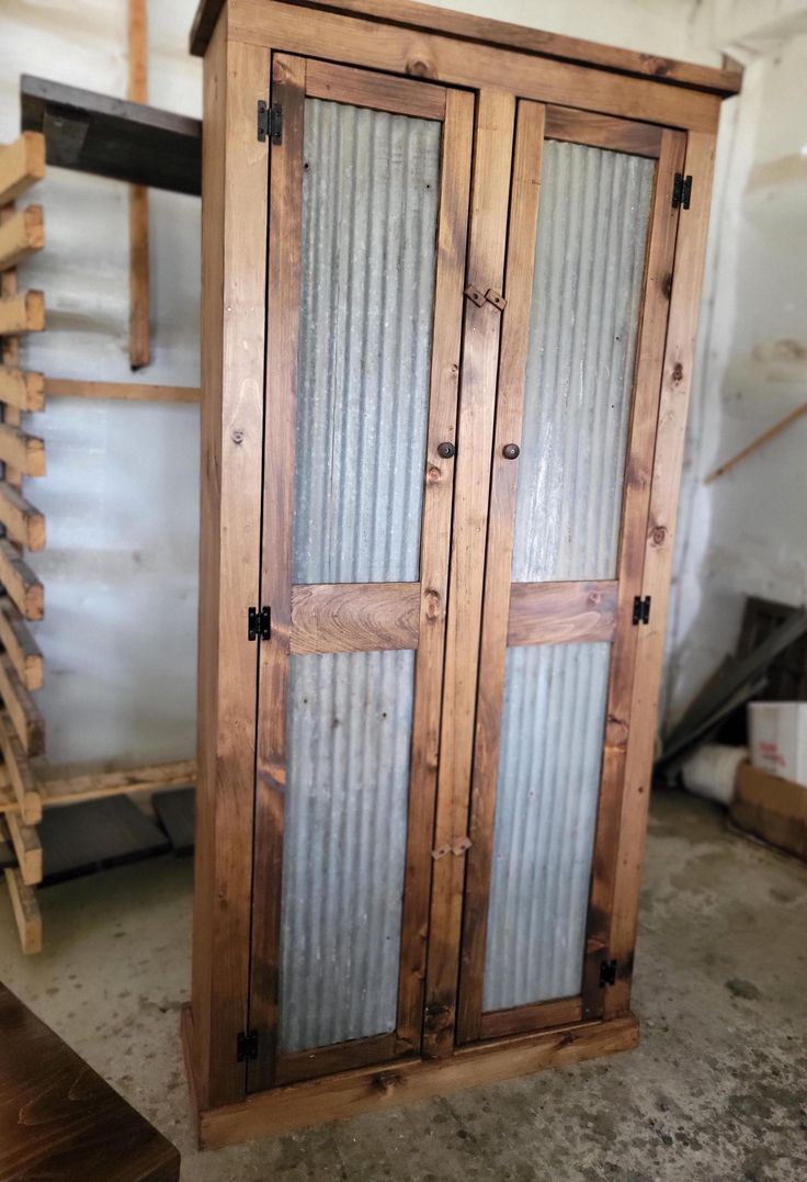 a tall wooden cabinet with glass doors in a storage room next to some pallets