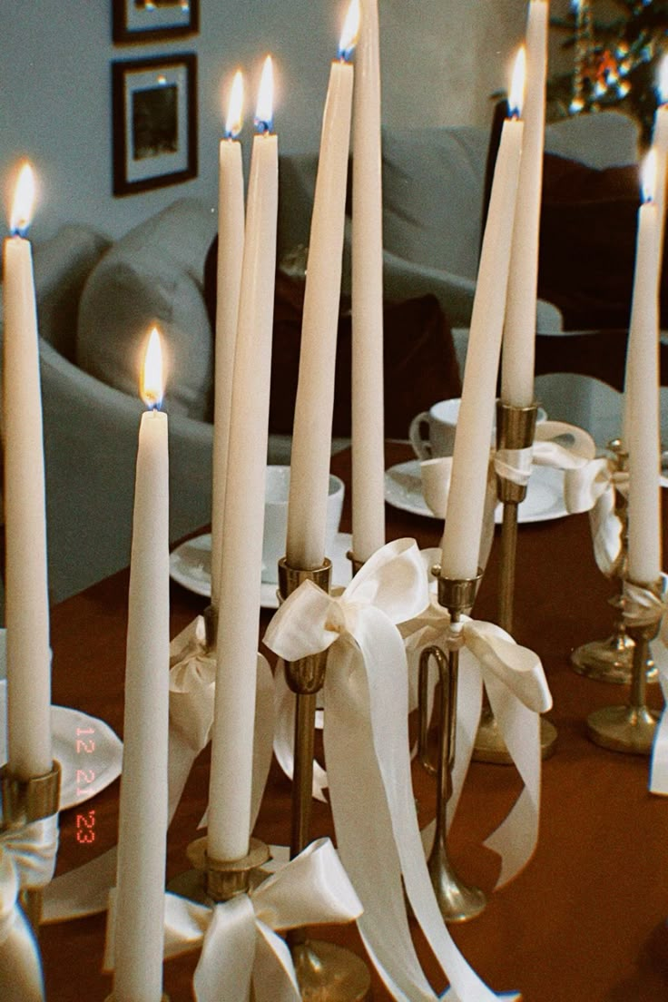 many white candles are lit on a table