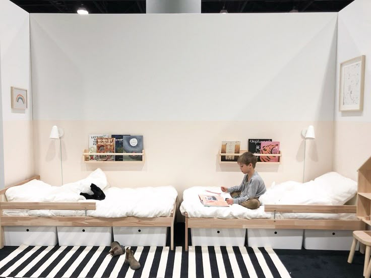 two children are sitting on their beds in a room with black and white rugs