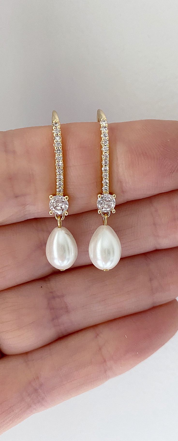 Our pearl drop bridal earrings are simply stunning! A simple classic earring. Little bit of bling, classic pearl, small drop... perfect combo! These long pearl drop earrings catch the light, packing serious sparkle for their size. Combining marquise crystals stones they're finished with glowing pearls. With just the right amount of sparkle, this dainty pair is perfect for brides, mother of the bride and bridesmaids alike. -Drop Pearls are light ivory- These Crystal and pearl wedding earrings will add a flawless finish to every bridal look. ** Delivery is 3 Weeks ** SHOP MORE STYLES https://www.etsy.com/ie/shop/BridalStar?ref=related&listing_id=768478002# *RETURNS- We accept returns . ** Bridal Jewelry Pearl Earrings, Diamond And Pearl Earrings, Bridal Jewelry Gold, Brides Mother, Bridal Jewelry Pearl, Elegant Pearl Jewelry, Jewelry Pearl Earrings, Bridal Drop Earrings, Gold Bridesmaid Jewelry