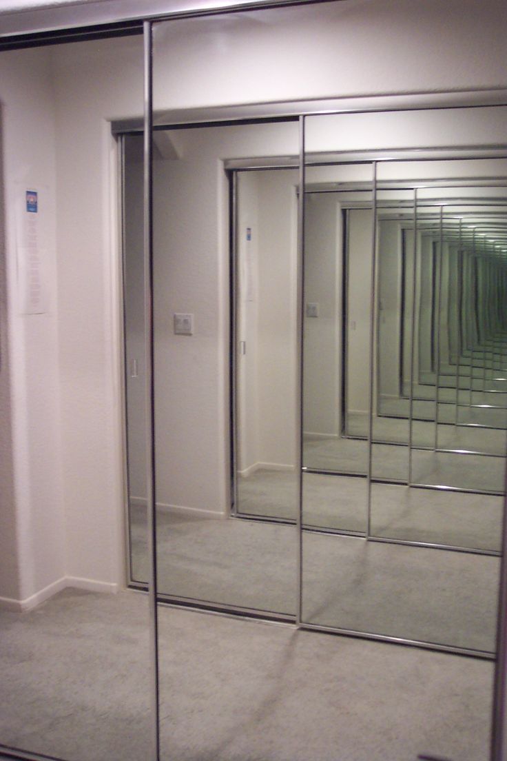 an empty room with mirrored walls and doors