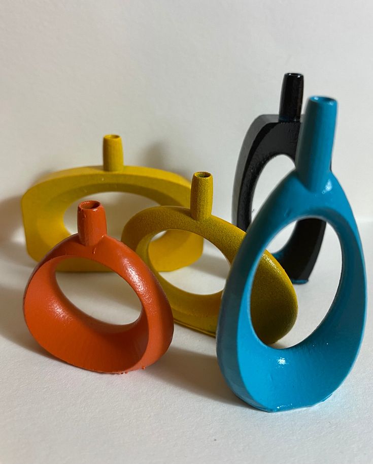 four different colored rings sitting next to each other on top of a white countertop