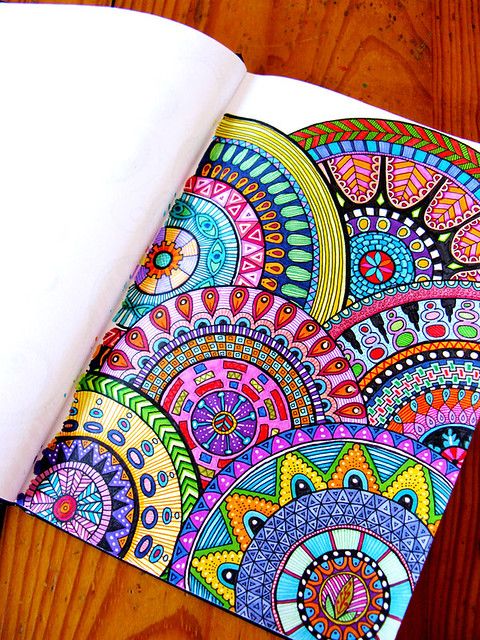 an adult coloring book with colorful designs on it