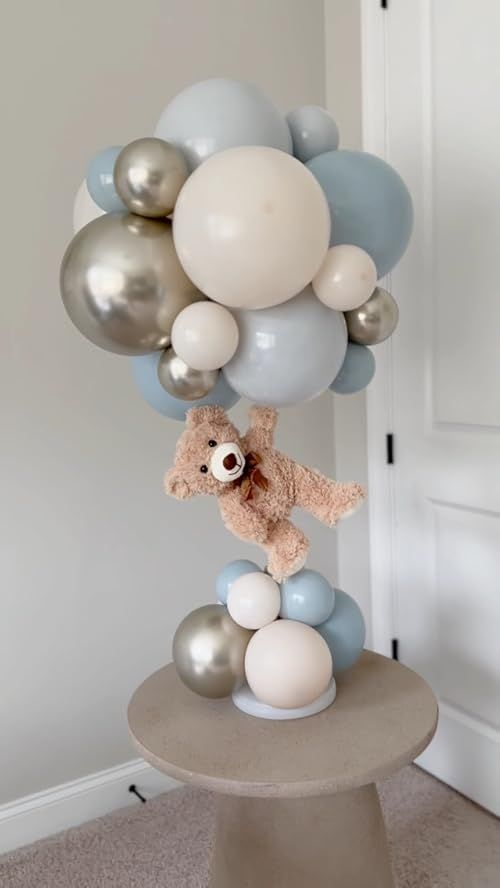 a teddy bear is on top of balloons