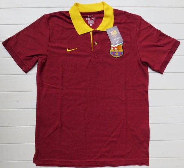 a maroon shirt with yellow trim and a badge on the collar is sitting against a white wall