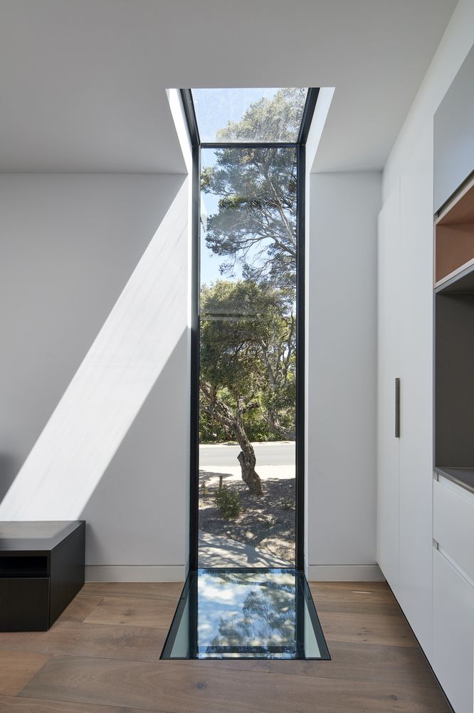 an empty room with a glass door leading to the outside and trees in the background