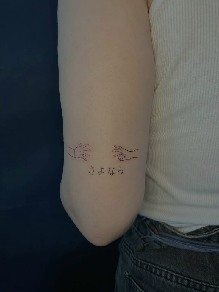 a woman's arm with two hands and the word love tattooed on her left arm