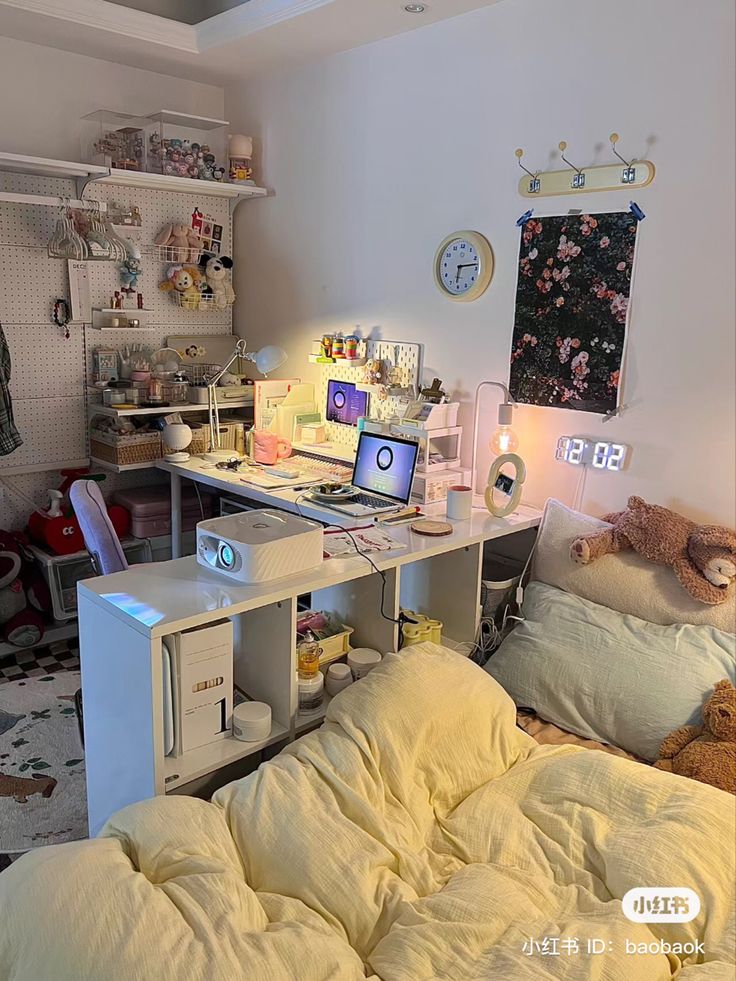 a room with a bed, computer desk and stuffed animals on the wall next to it