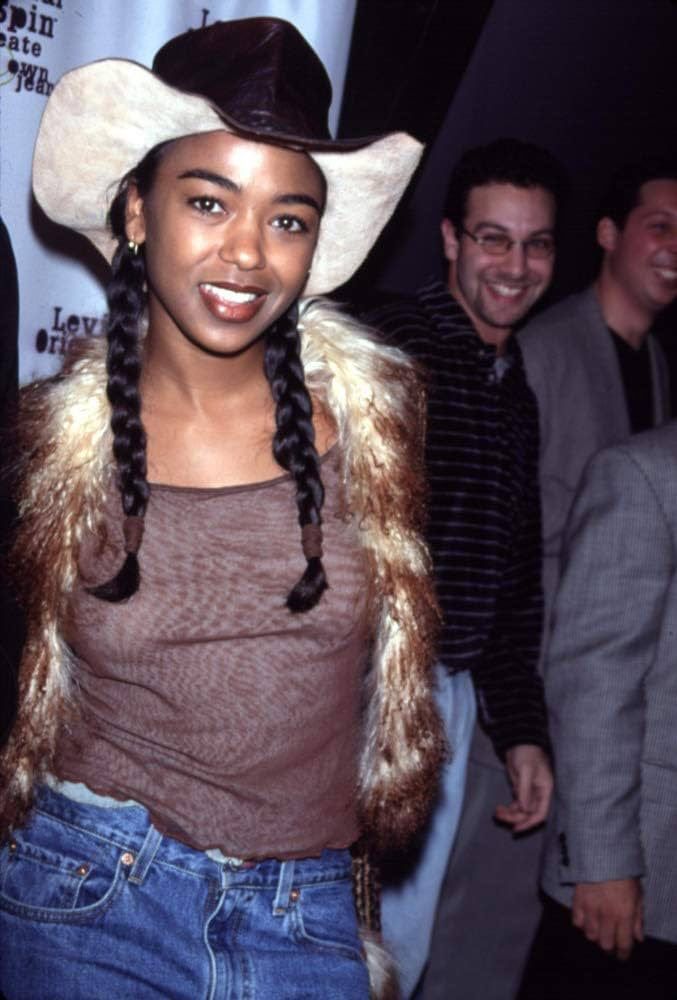 a woman wearing a cowboy hat standing next to two men