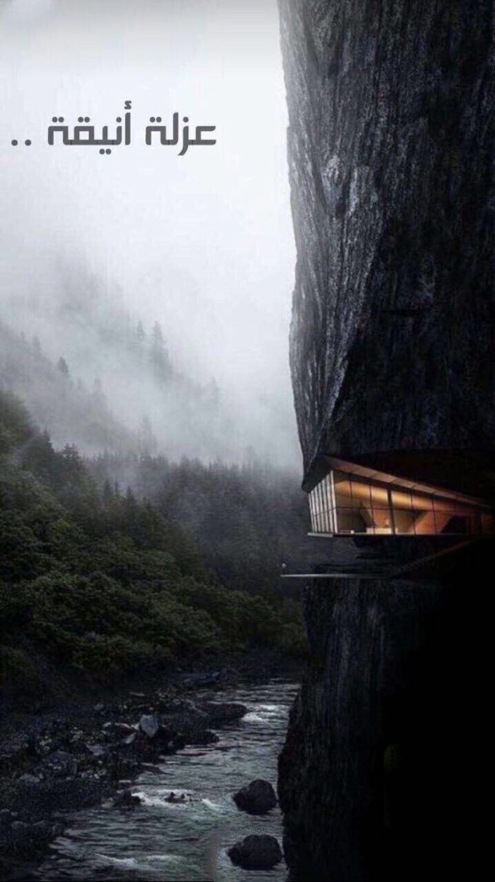 an image of a house in the middle of a cliff with water and trees around it