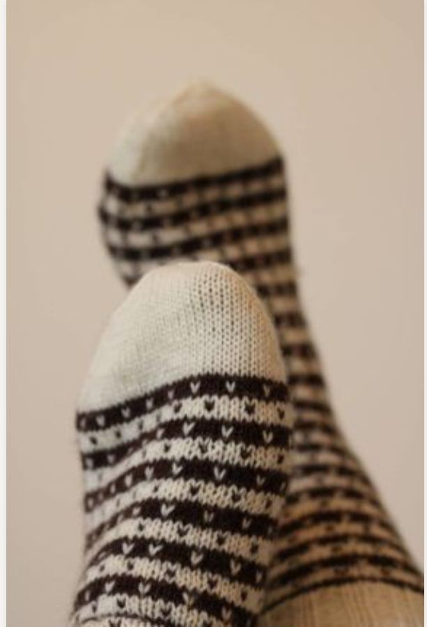 someone's feet in striped socks on a white surface