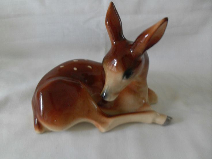 a deer figurine sitting on top of a white sheet