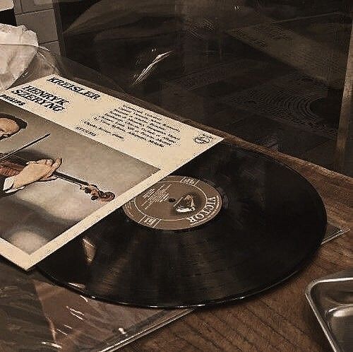 an old record player is sitting on the table with its cover pulled up to reveal it's original album