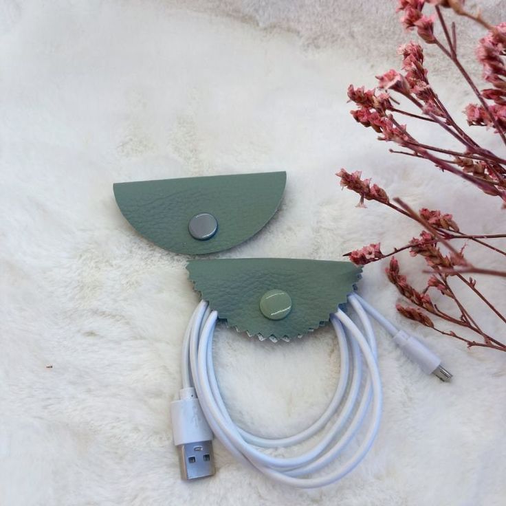 two pieces of green leather sitting on top of a white rug next to a plant