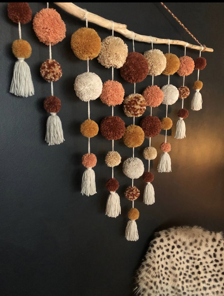 a wall hanging with pom poms and tassels