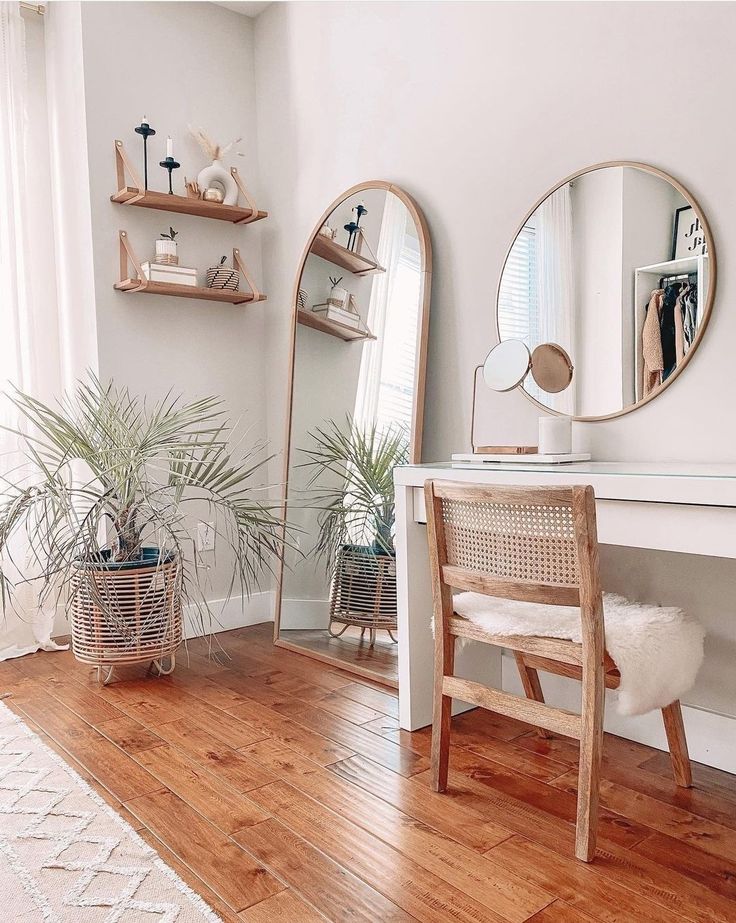 a room with two mirrors, a chair and some plants