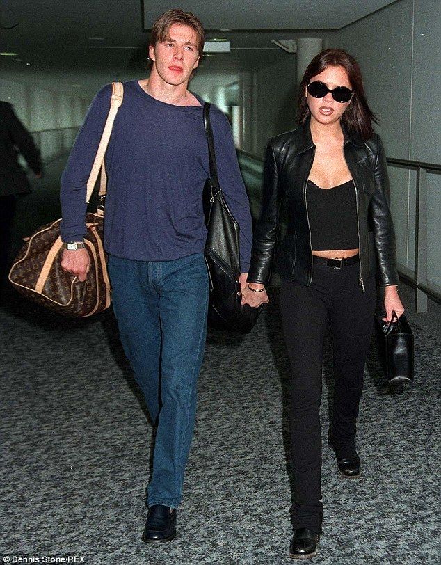 a man and woman are walking through an airport holding hands with each other as they walk towards the camera