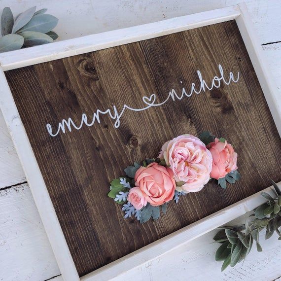 a wooden sign with flowers on it