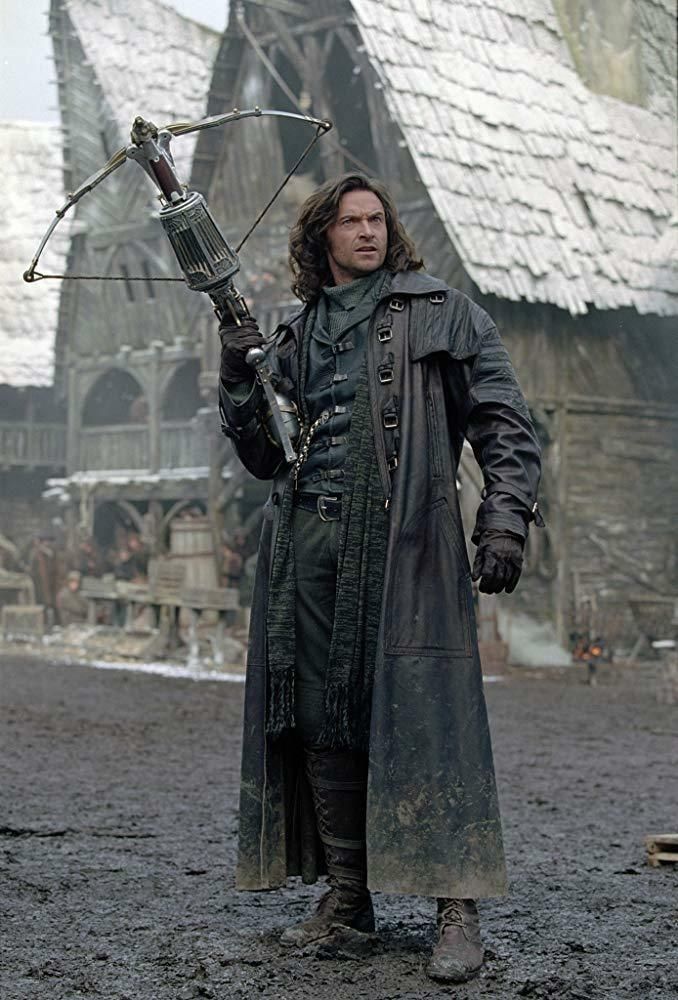 a man holding a bow and arrow in front of an old building with snow on the ground