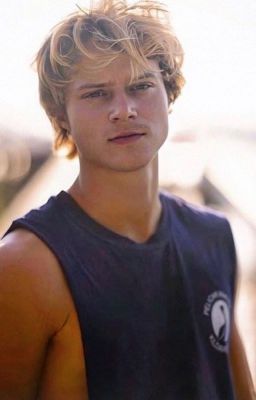 a young man in a tank top is posing for the camera with his hand on his hip