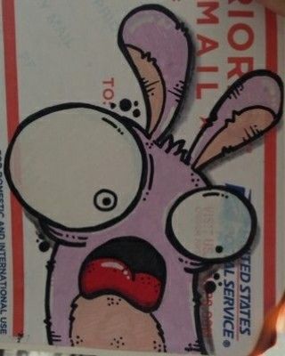 a close up of a person holding a ticket with a cartoon rabbit on it's face